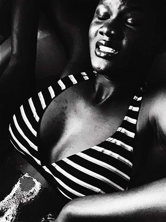Black and white photo of woman in striped bikini